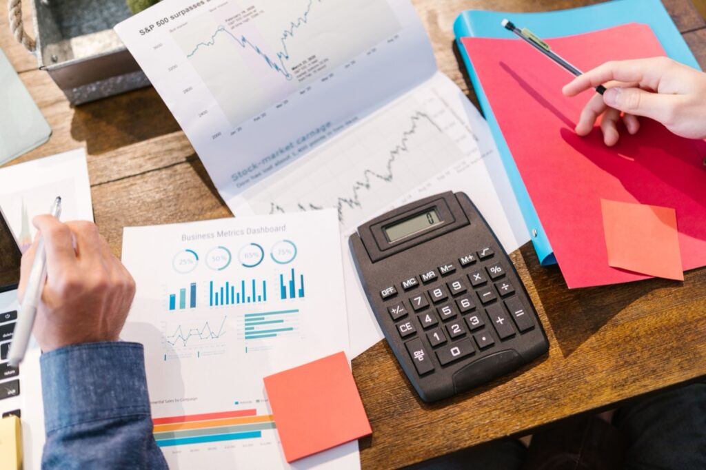 Documentos con métricas empresariales, gráficos y calculadora para analizar el valor de una empresa